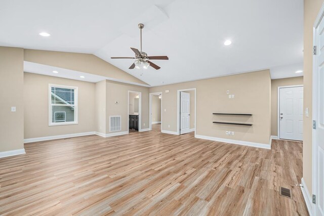 unfurnished living room featuring light wood-style floors, visible vents, vaulted ceiling, and a fireplace