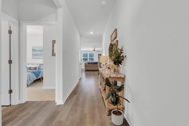 corridor with recessed lighting, baseboards, and light wood finished floors