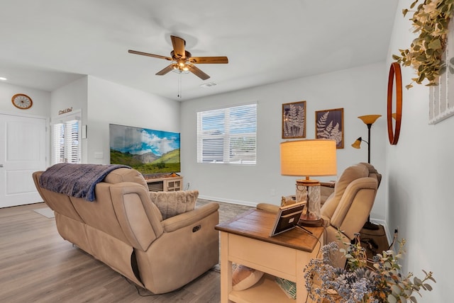 living room featuring visible vents, ceiling fan, baseboards, and wood finished floors