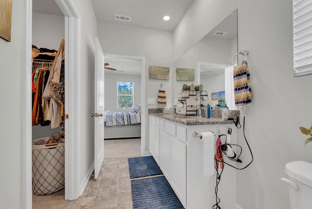 ensuite bathroom with ensuite bathroom, toilet, vanity, visible vents, and baseboards