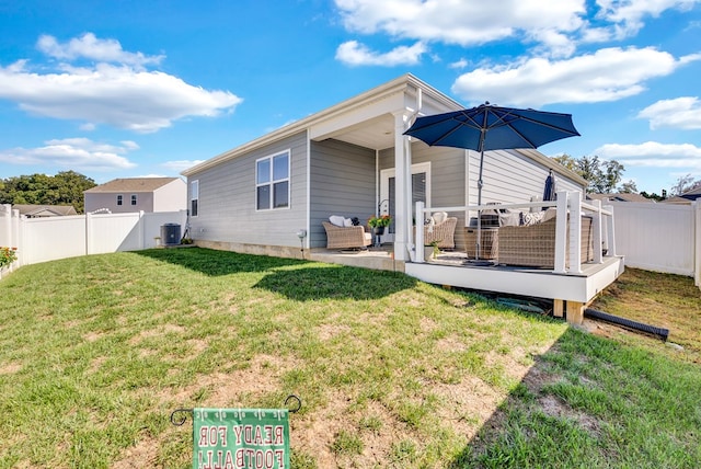 back of house featuring a fenced backyard, a lawn, a wooden deck, and central AC unit