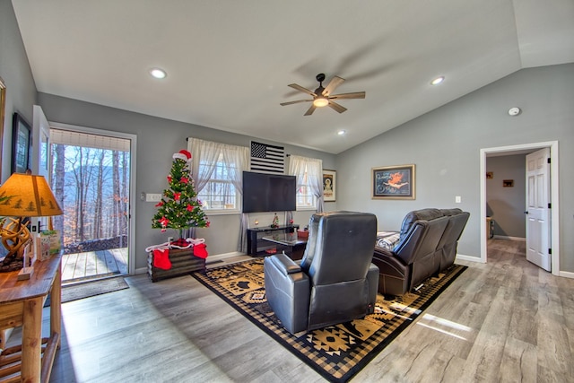 living room featuring vaulted ceiling, light wood-type flooring, a ceiling fan, and baseboards