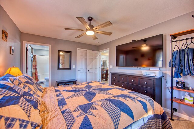 bedroom with ensuite bath, baseboards, and ceiling fan