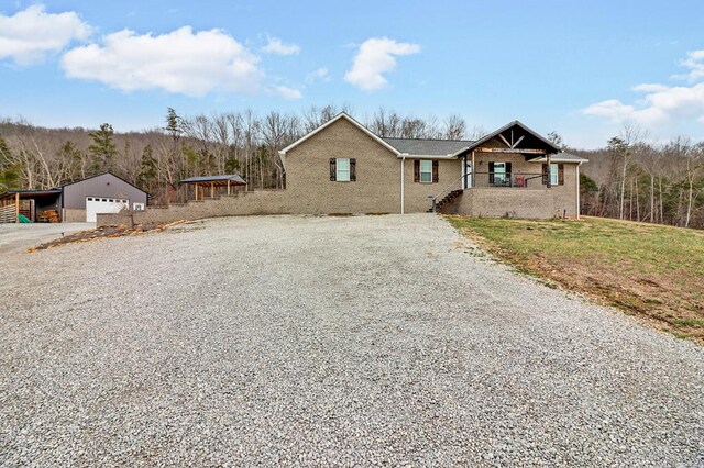 view of front of home featuring an outbuilding, gravel driveway, and a detached garage