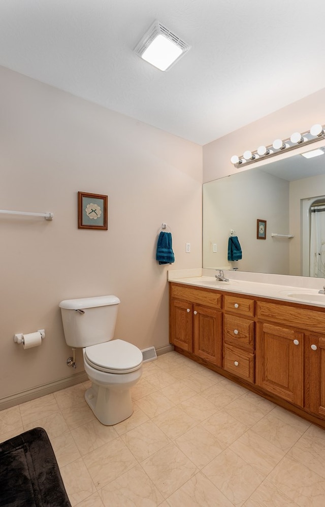 full bath featuring toilet, a sink, visible vents, baseboards, and double vanity