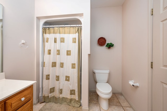 bathroom featuring baseboards, toilet, a shower with curtain, tile patterned flooring, and vanity