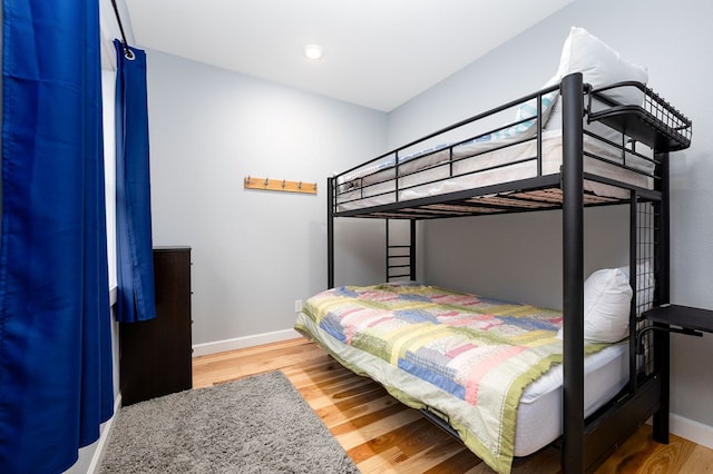 bedroom with baseboards and wood finished floors