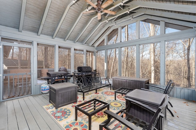 sunroom featuring a ceiling fan and lofted ceiling with beams