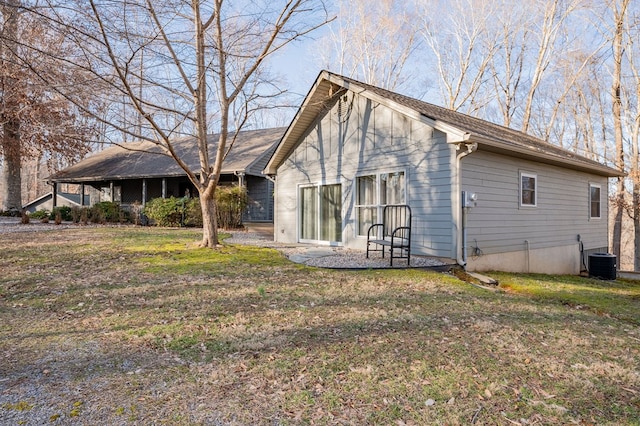 back of property featuring cooling unit and a lawn