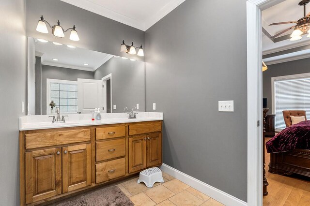 ensuite bathroom featuring double vanity, baseboards, connected bathroom, ornamental molding, and a sink