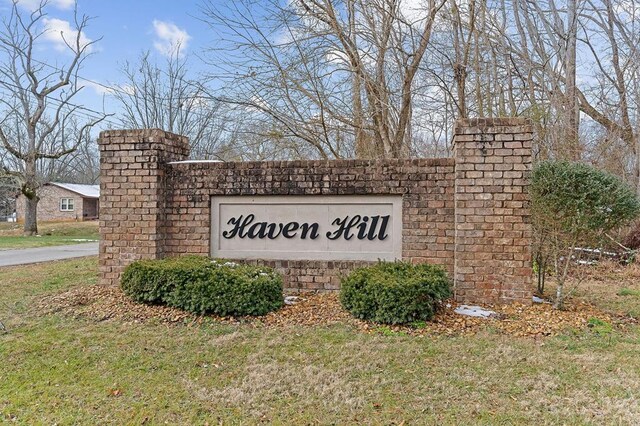 community / neighborhood sign featuring a lawn