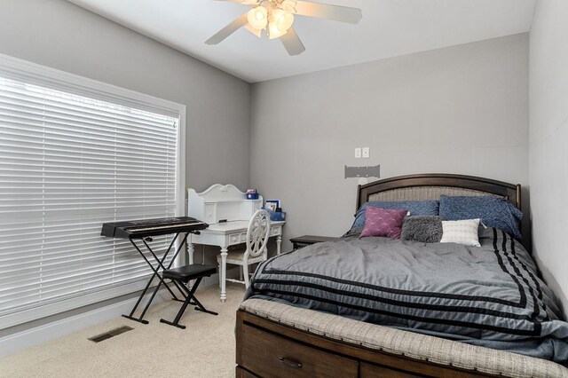 bedroom with ceiling fan, visible vents, and light colored carpet