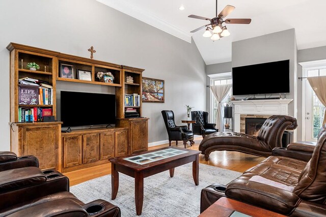 living room featuring vaulted ceiling, light wood-type flooring, and a healthy amount of sunlight