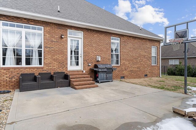 rear view of house featuring entry steps, a shingled roof, crawl space, a patio area, and brick siding