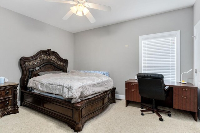 bedroom featuring light carpet, a ceiling fan, and baseboards