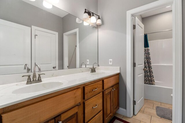 full bath with shower / tub combo with curtain, double vanity, a sink, and tile patterned floors