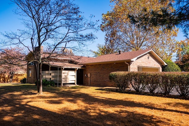 view of front of home featuring roof with shingles, a front lawn, and brick siding