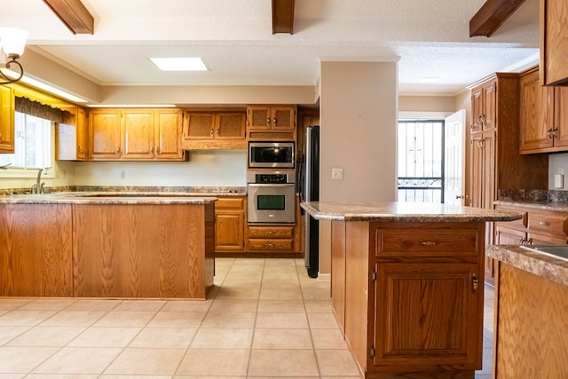 kitchen with brown cabinets, light tile patterned floors, stainless steel appliances, and a center island