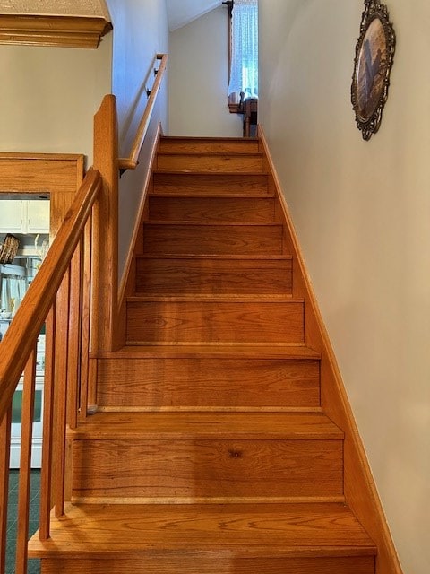 staircase with lofted ceiling and baseboards