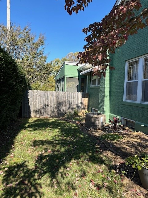 view of yard with central AC unit and fence