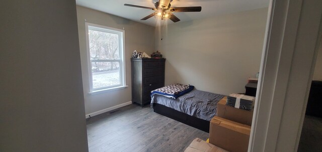 bedroom with a ceiling fan, baseboards, and wood finished floors