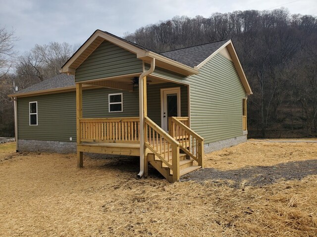 view of front facade with crawl space and roof with shingles