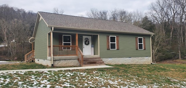 view of front of house featuring covered porch, roof with shingles, crawl space, and a lawn