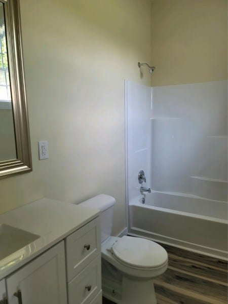 full bathroom with toilet, vanity, wood finished floors, and bathing tub / shower combination