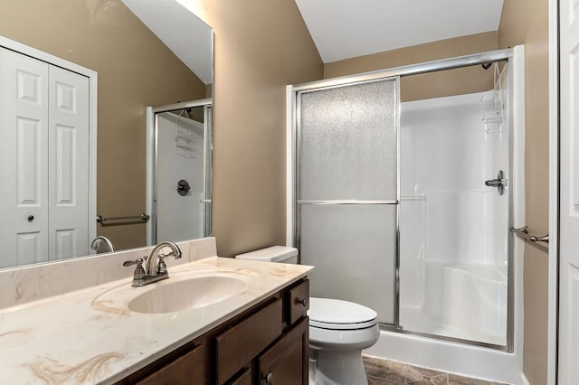 full bathroom featuring a closet, vanity, toilet, and a shower stall