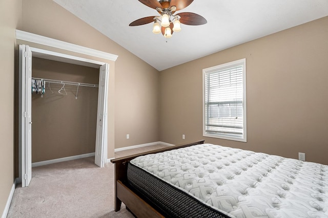 bedroom featuring lofted ceiling, a closet, a ceiling fan, light carpet, and baseboards