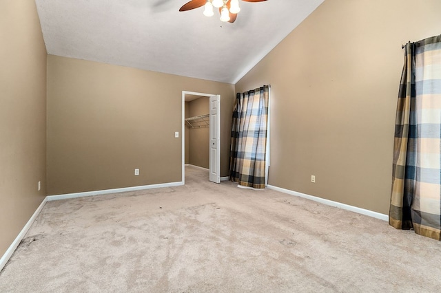 unfurnished bedroom featuring lofted ceiling, light carpet, baseboards, and a ceiling fan