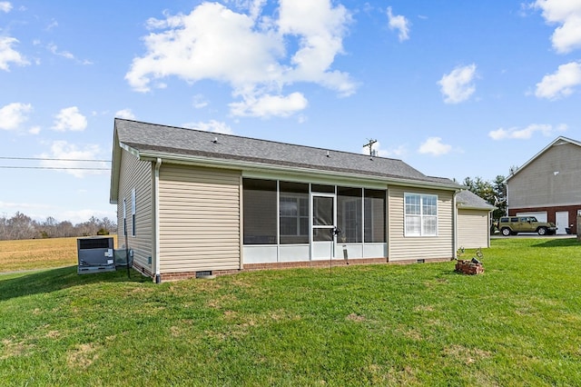 rear view of house with crawl space, a sunroom, central AC unit, and a lawn