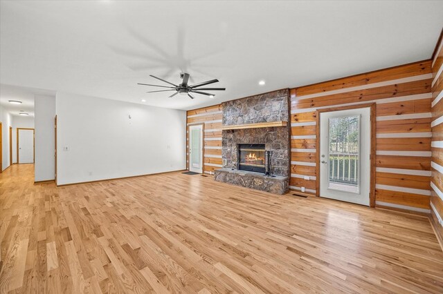 unfurnished living room with visible vents, a fireplace, light wood-style flooring, and ceiling fan