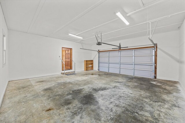 garage featuring a garage door opener and baseboards