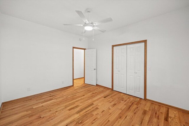 unfurnished bedroom featuring baseboards, light wood-style flooring, a ceiling fan, and a closet