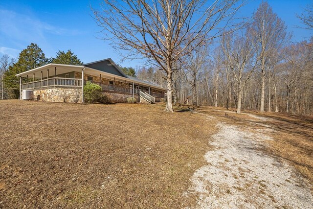 view of side of home with a porch and stone siding