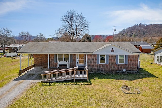 view of front of property featuring an attached carport, aphalt driveway, brick siding, and a front yard