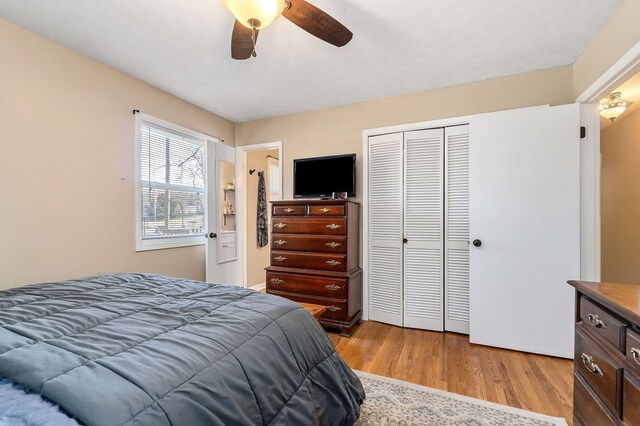 bedroom featuring light wood-type flooring, ceiling fan, and a closet