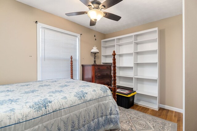 bedroom featuring ceiling fan, baseboards, and wood finished floors