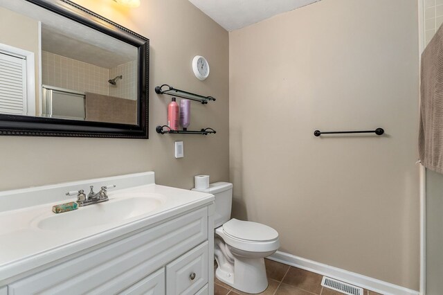 bathroom featuring visible vents, toilet, vanity, tile patterned flooring, and baseboards