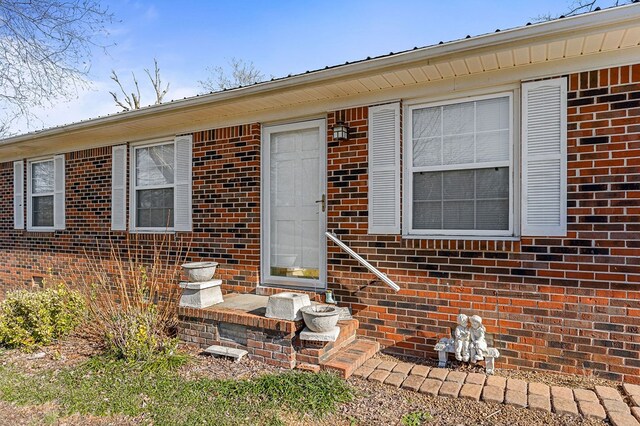 property entrance featuring brick siding