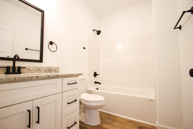 full bathroom featuring toilet, wood finished floors, shower / tub combination, and vanity