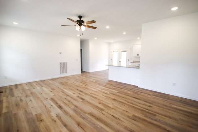 unfurnished living room with recessed lighting, visible vents, light wood-style flooring, a ceiling fan, and baseboards