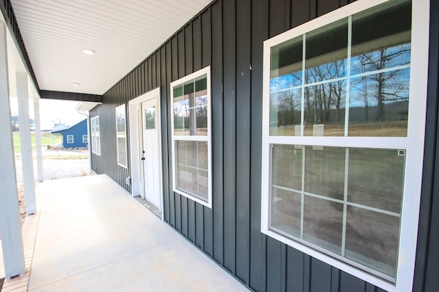 view of side of home featuring board and batten siding and covered porch