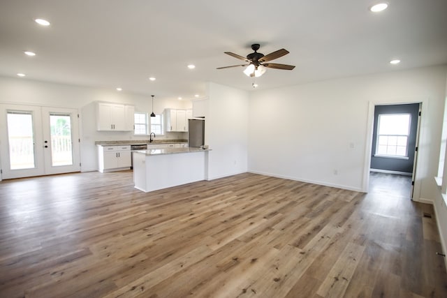 kitchen featuring pendant lighting, open floor plan, white cabinetry, and dishwashing machine