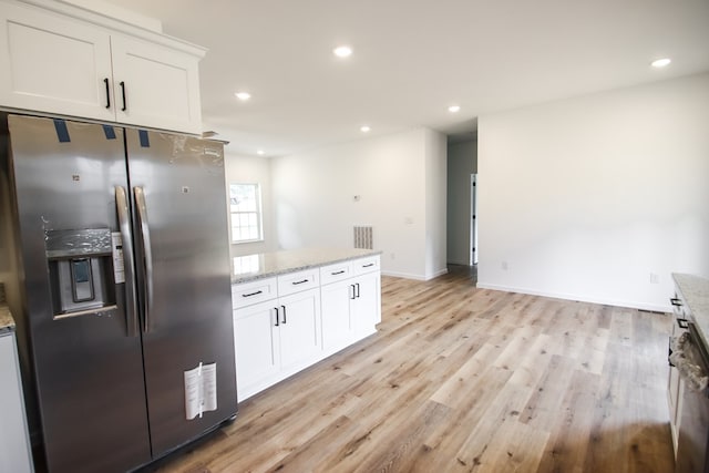 kitchen featuring light stone counters, stainless steel refrigerator with ice dispenser, white cabinetry, and recessed lighting