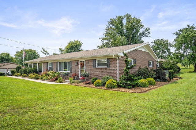 ranch-style house featuring a front lawn and brick siding