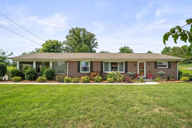 ranch-style home featuring brick siding and a front yard