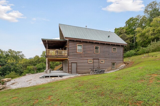 rear view of house featuring a yard, stairway, metal roof, and a wooden deck