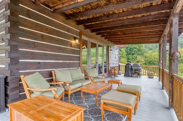 wooden deck with grilling area and an outdoor living space